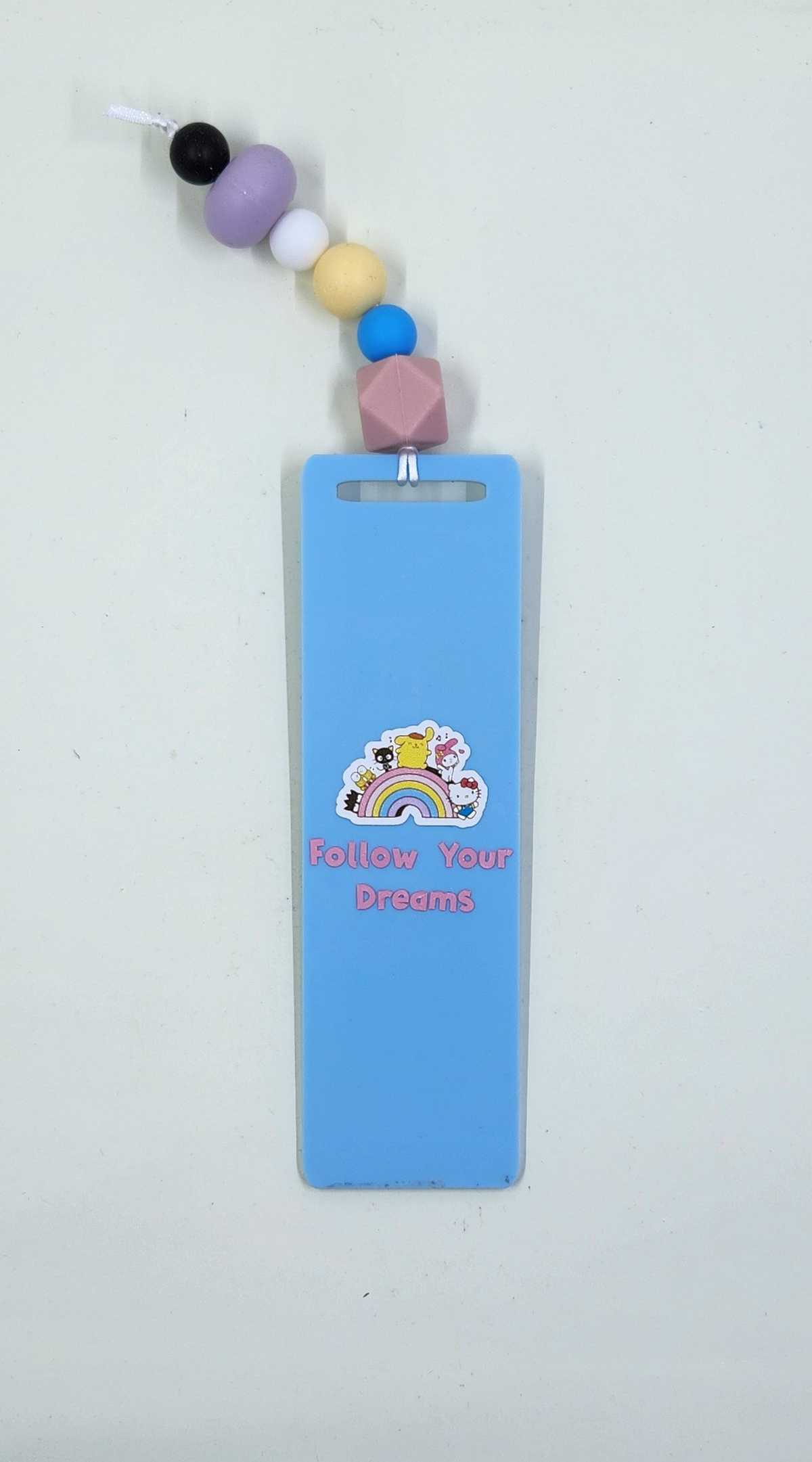 A blue acrylic bookmark with a rainbow design and Sanrio characters, complete with a cord and silicone beads in various colors.