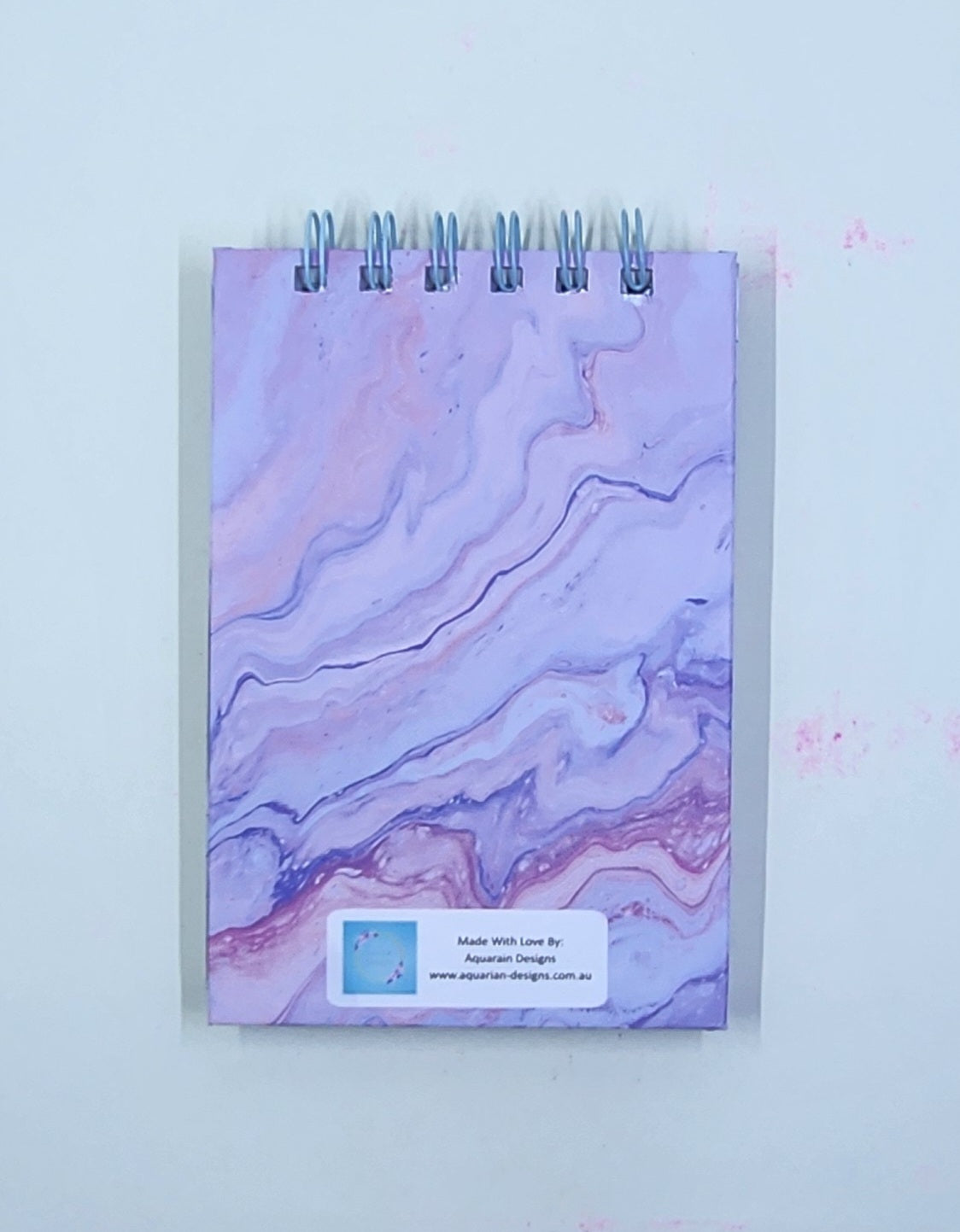 Marbled notepad with a visible brand label on a white background