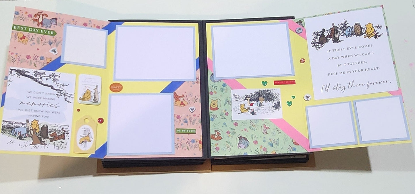 Open photo book with Winnie the pooh decorative pages and illustrations on a white background