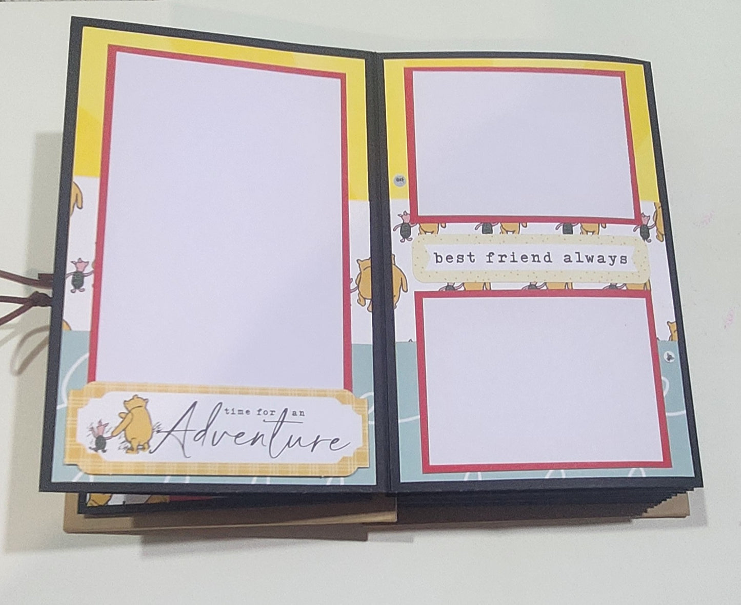 Open photo book with decorative pages featuring text and illustrations on a white background