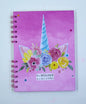 Notebook with unicorn and floral design on a pink background