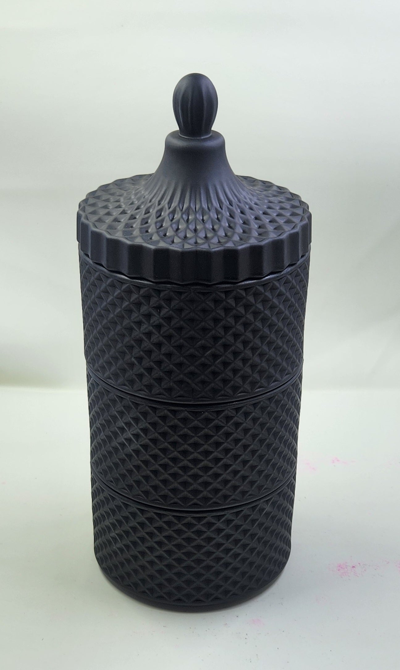 Black textured container with a lid on a white background