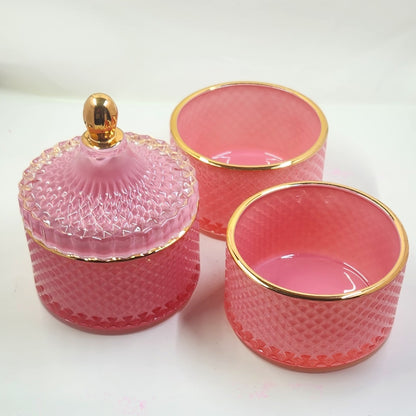 Set of pink glass containers with gold rims on a white background