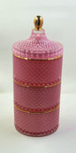 Pink ceramic jar with gold accents on a white background