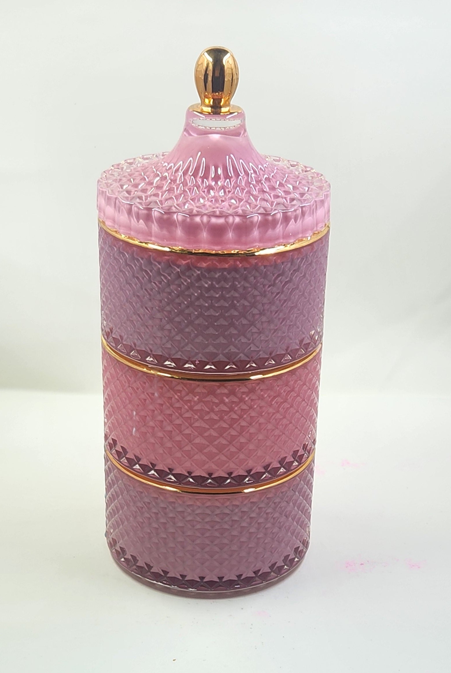 Pink textured cylindrical container with gold accents on a white background