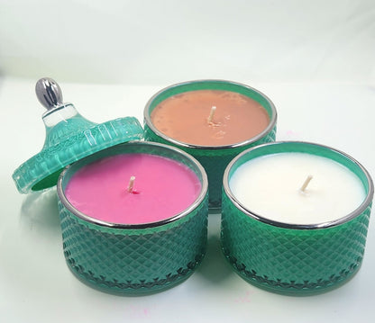 Three teal textured candle holders with pink, brown, and white candles on a white background