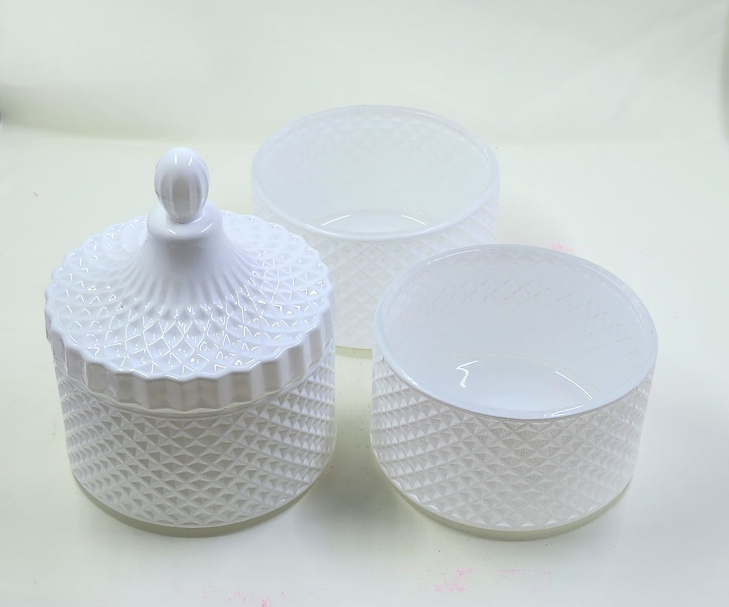 Set of white textured jars with lid on a light background