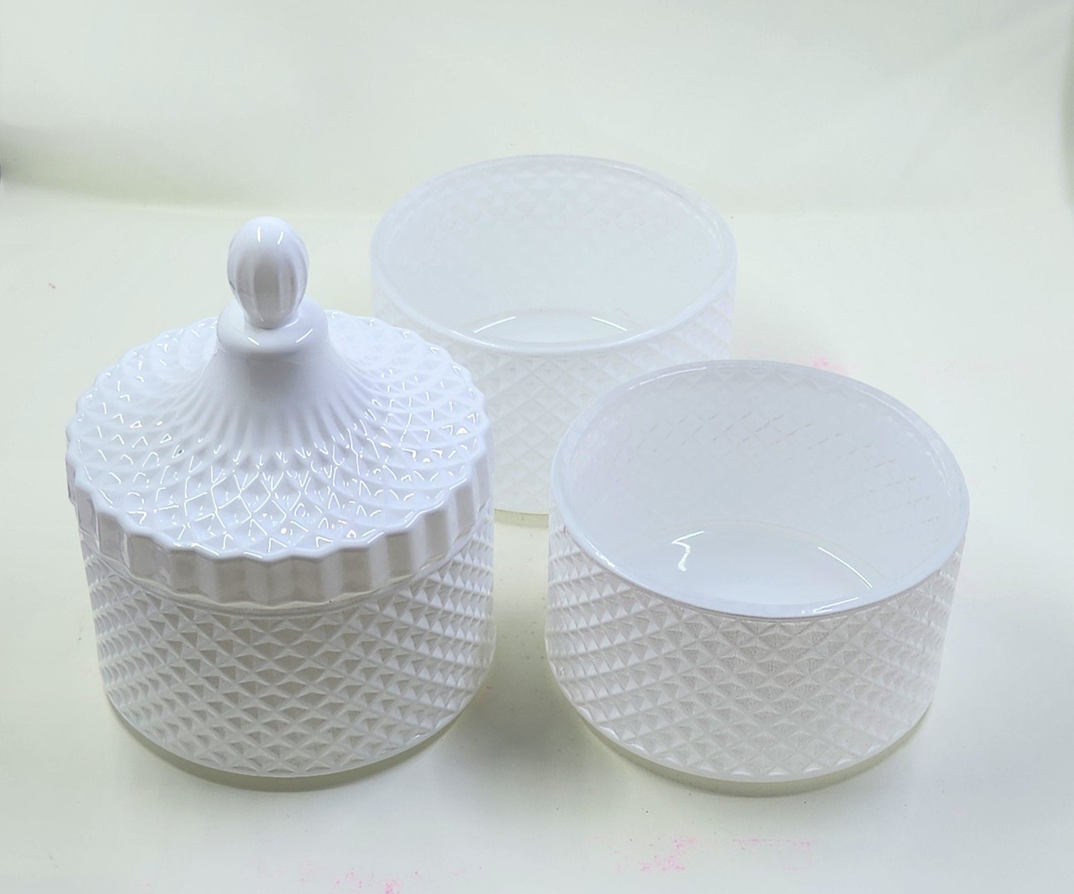 Set of white textured jars with lid on a light background
