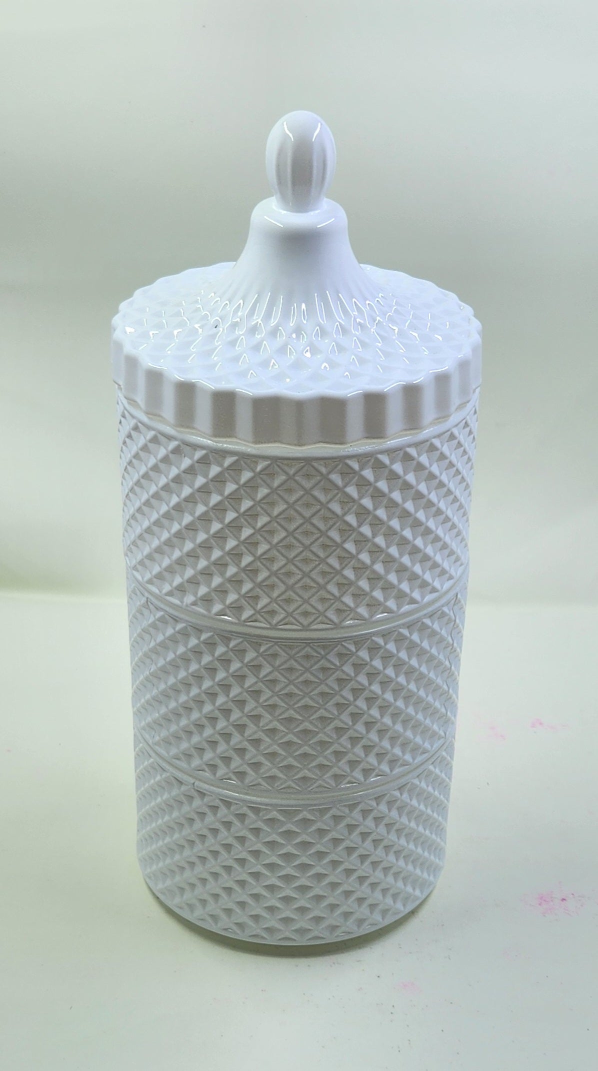 White textured jar with a lid on a light background