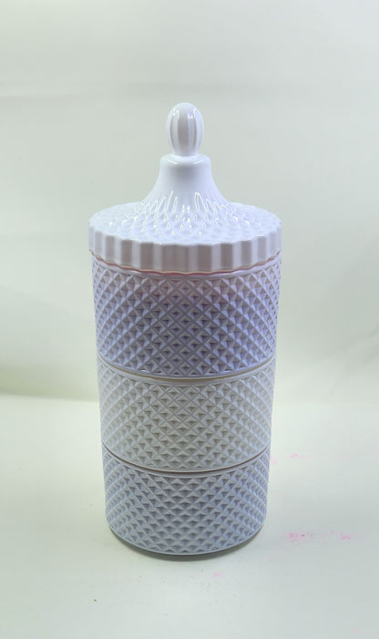 Decorative white ceramic jar with textured design on a light background