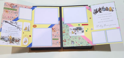 Open photo book with Winnie the pooh decorative pages and illustrations on a white background